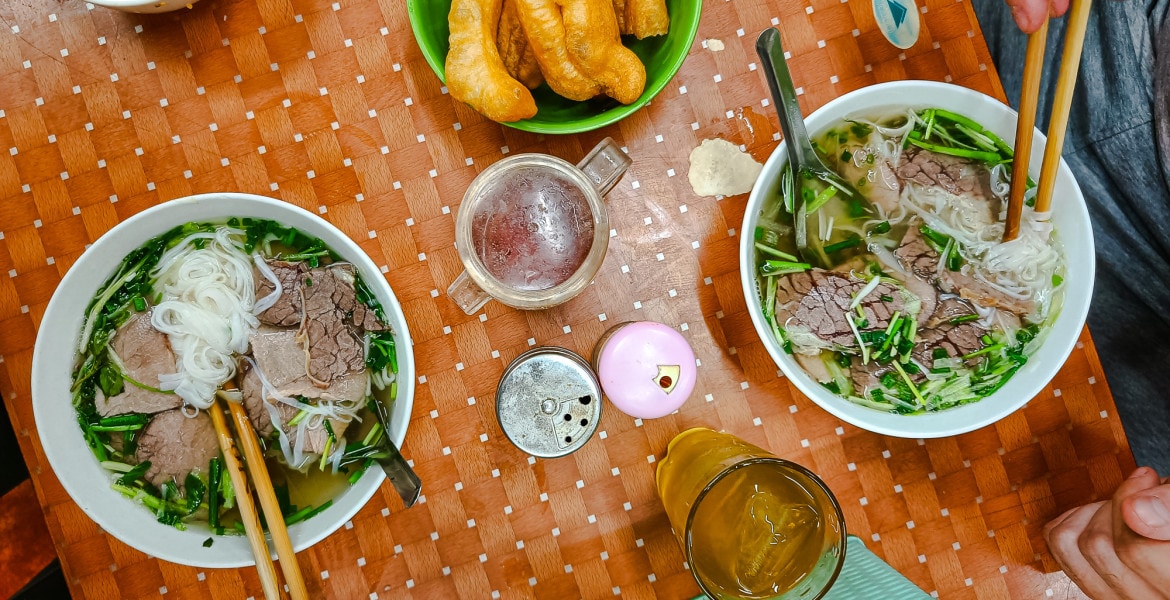 Table setting at a street food place in Hanoi serving Pho, a Vietnamese noodle soup with beef