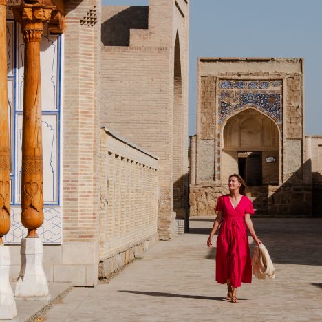 Girl in pink flowy dress walking through Chor Bakr Memorial Complex near Bukhara Uzbekistan