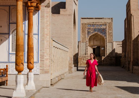 Girl in pink flowy dress walking through Chor Bakr Memorial Complex near Bukhara Uzbekistan