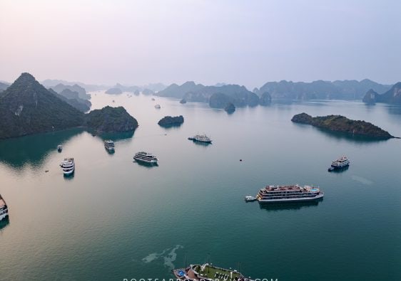 Drone shot view of Halong bay with its cruise boats in between the limestone formations in the water
