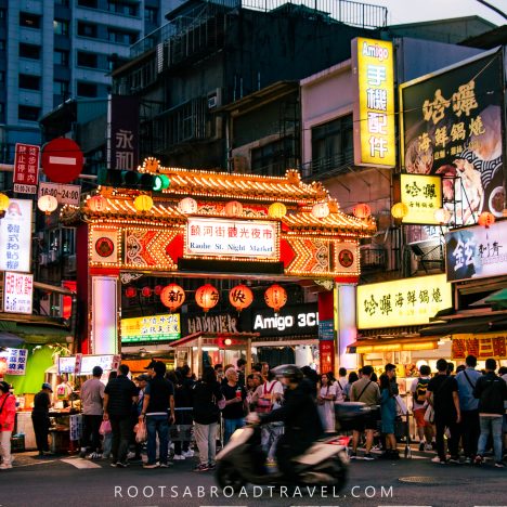 Many people and neon lights at Raohe street night market in Taipei Taiwan
