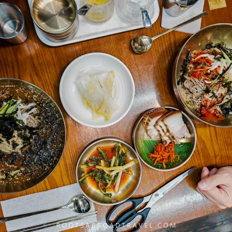 Delicious Korean Makguksku with fresh vegetables, eggs, and seaweed in stainless steel bowls, showcasing authentic Korean cuisine in Seoul.