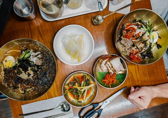 Delicious Korean Makguksku with fresh vegetables, eggs, and seaweed in stainless steel bowls, showcasing authentic Korean cuisine in Seoul.